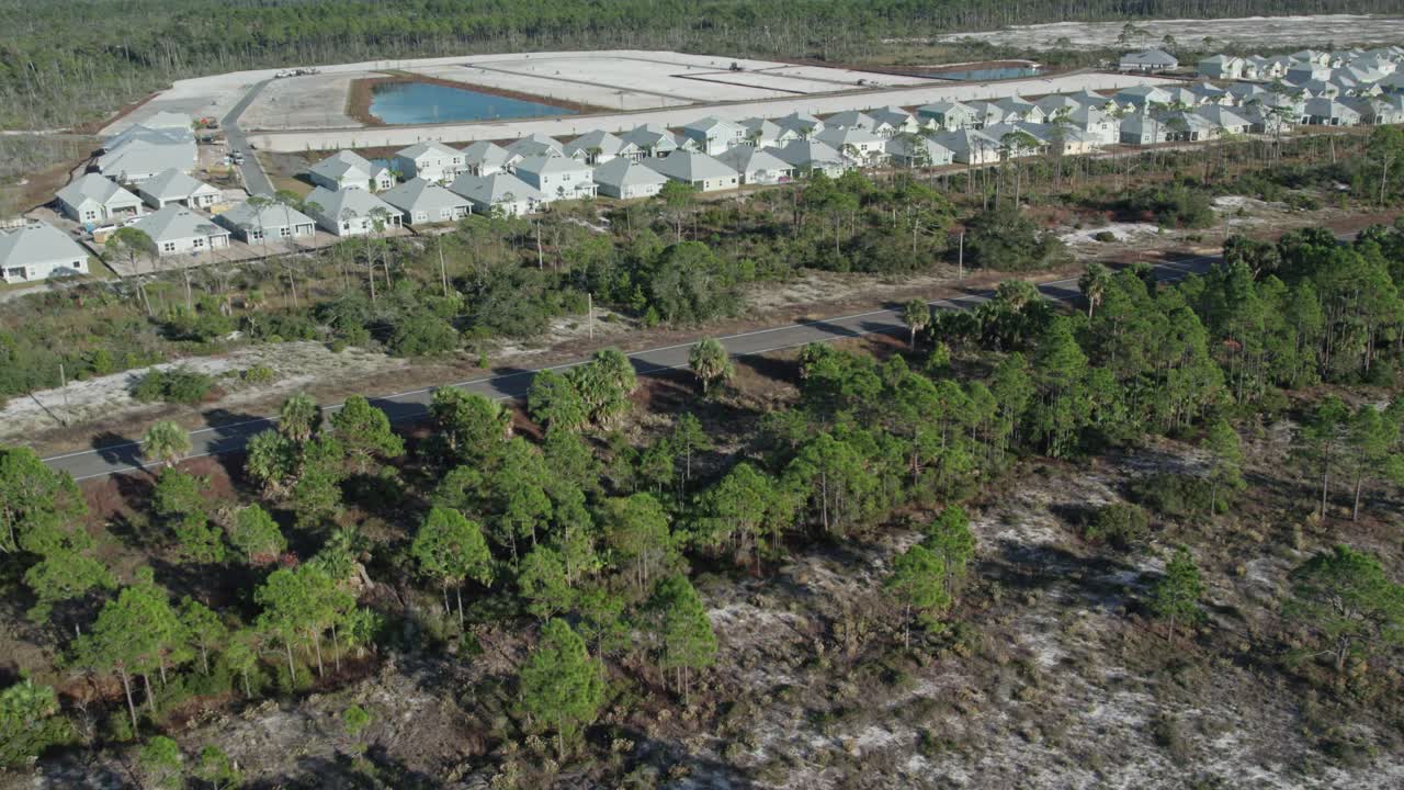 aerial que muestra el bosque recuperado y la nueva subdivisión que se está construyendo a lo largo de una línea costera de florida