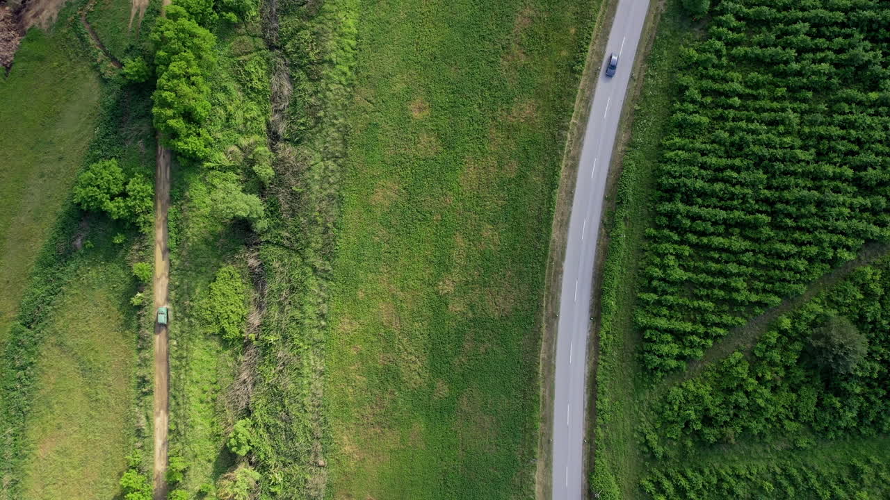 좁은 길을 달리는 자동차와 함께 콘크리트와 흙길을 내려다보고 있다