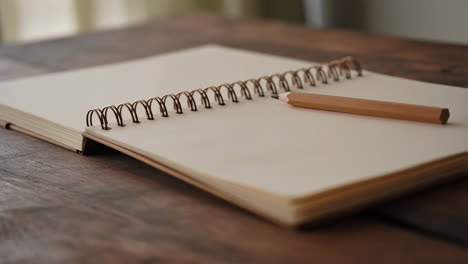 open notebook and pencil on a wooden table