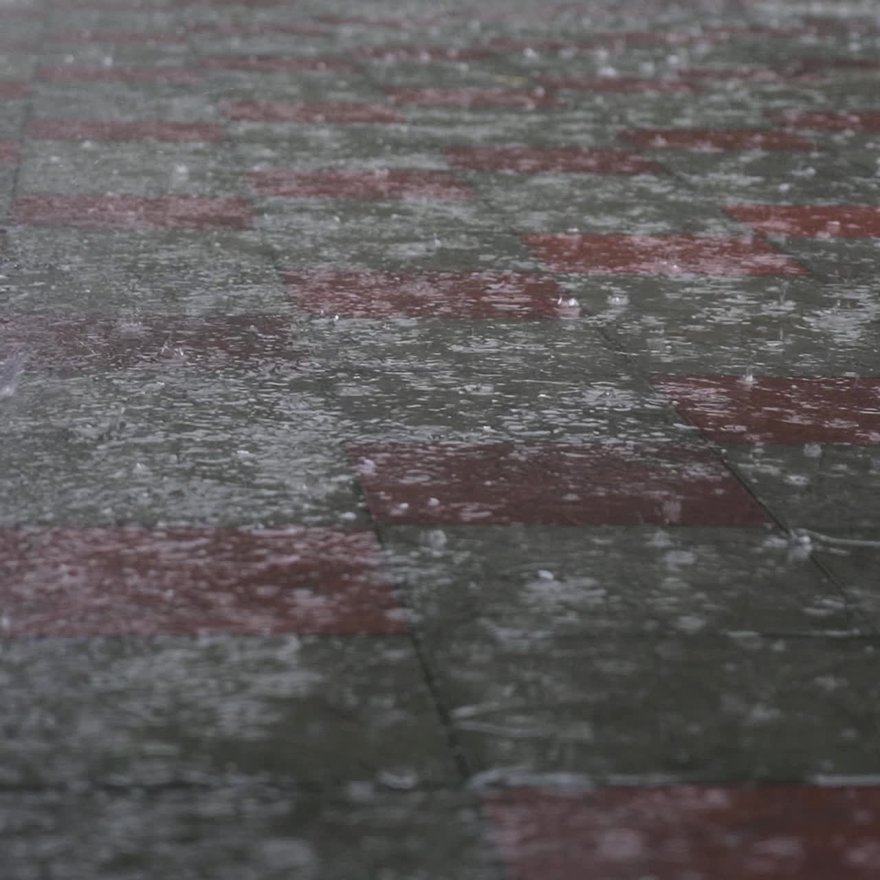 Heavy rain on a city street. Great summer downpour. Large drops fall on the asphalt.