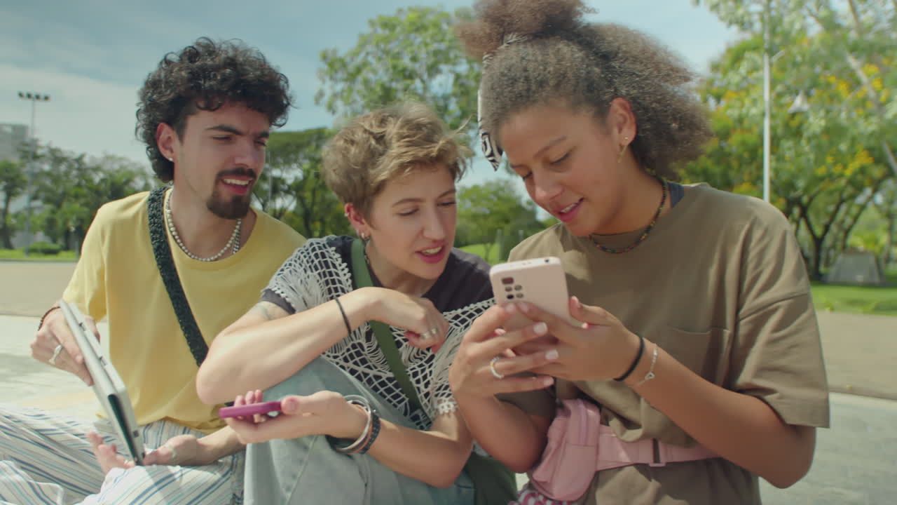 Young Friends Discussing Social Media Posts on Gadgets