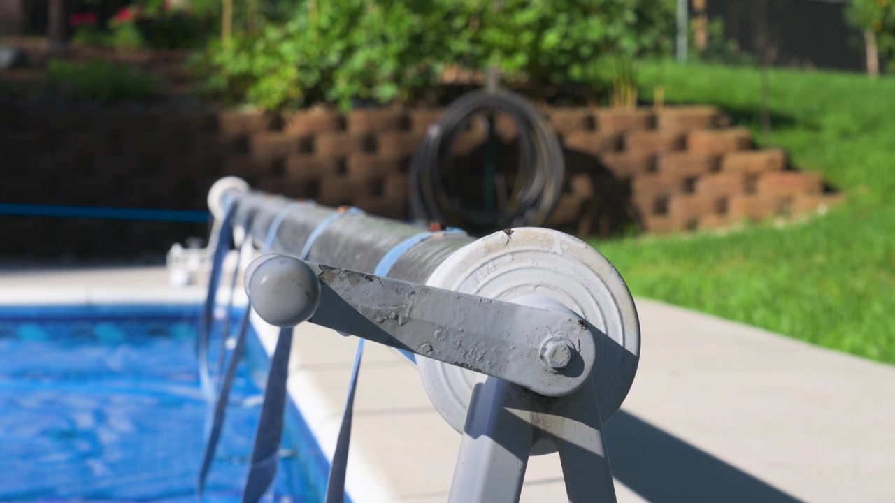 Montée en très gros plan pour révéler les composants d'une couverture solaire pour piscine enterrée