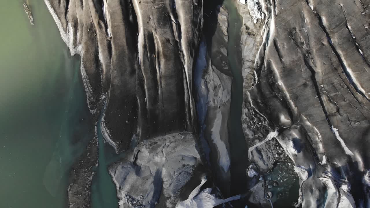 sobrevuelo aéreo sobre el hielo y las grietas en el glaciar del ródano cerca del paso de montaña de furka en la frontera de valais y uri en suiza con una panorámica desde el lago glacial hasta los picos de las montañas