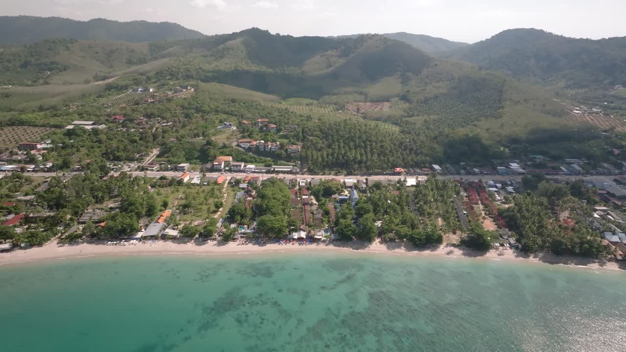 Aerial View of Tropical Beach Village with Mountains and Turquoise Ocean