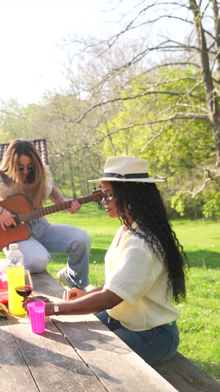 Friends enjoying a picnic with music and wine