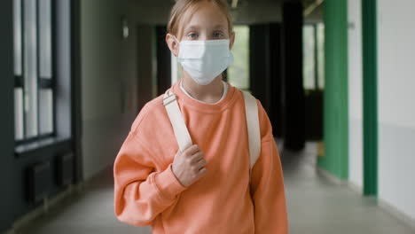 schoolgirl with face mask in school corridor.