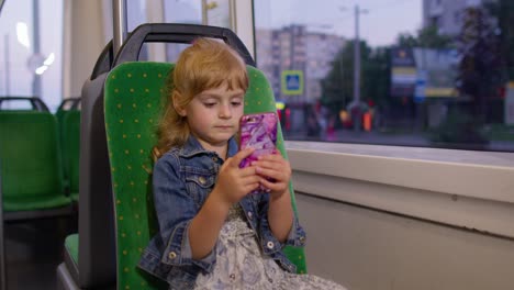 Girl-playing-on-smartphone,-chatting,-texting,-browsing-social-media-while-traveling-by-tram-to-city