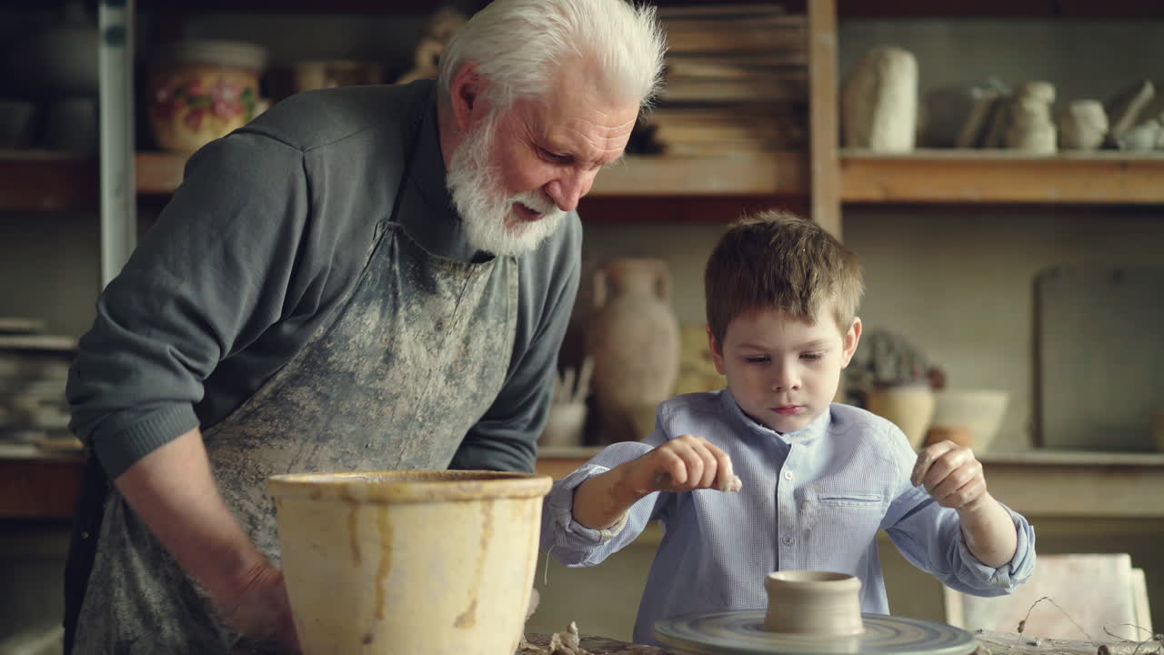 Grandpa and grandson making pottery