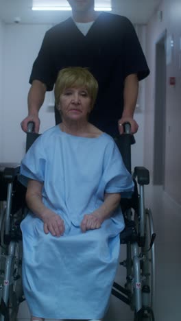 elderly patient in wheelchair being assisted by a nurse