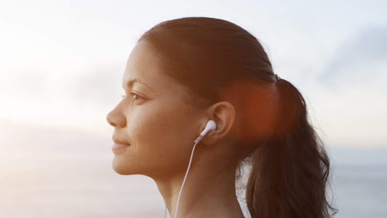 아름다운 여성 초상화가 음악을 듣고 바다를 바라보고 있습니다.