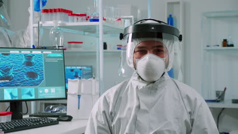 Overworked-chemist-sitting-in-equipped-lab-wearing-coverall