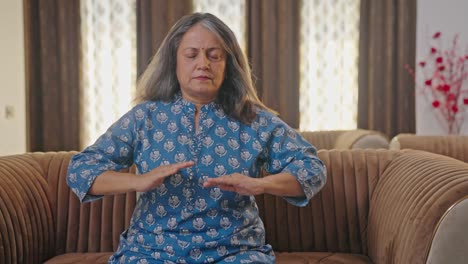 Old-Indian-woman-doing-breathe-in-breathe-out-exercise