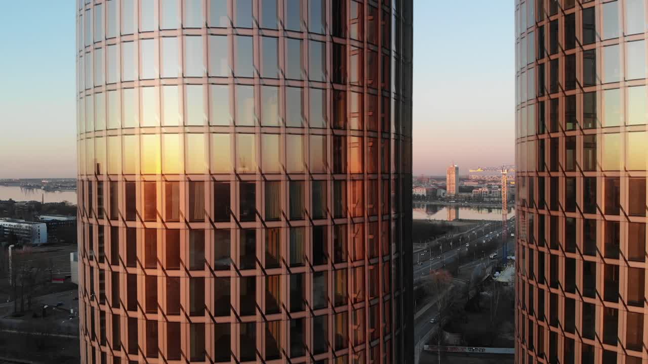 reflejo de rayos de sol en dos edificios de oficinas de vidrio con paisaje urbano de fondo en riga, letonia