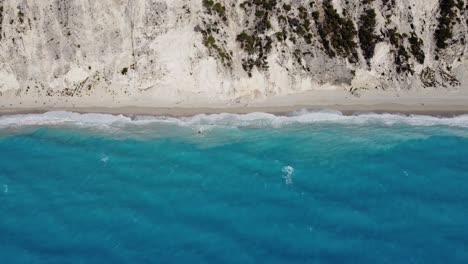 aerial view of waves crashing on coastline of egremni beach in ionian island lefkada