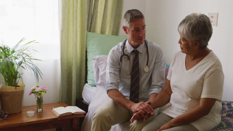 médico ayudando a una anciana en su habitación de la casa de retiro