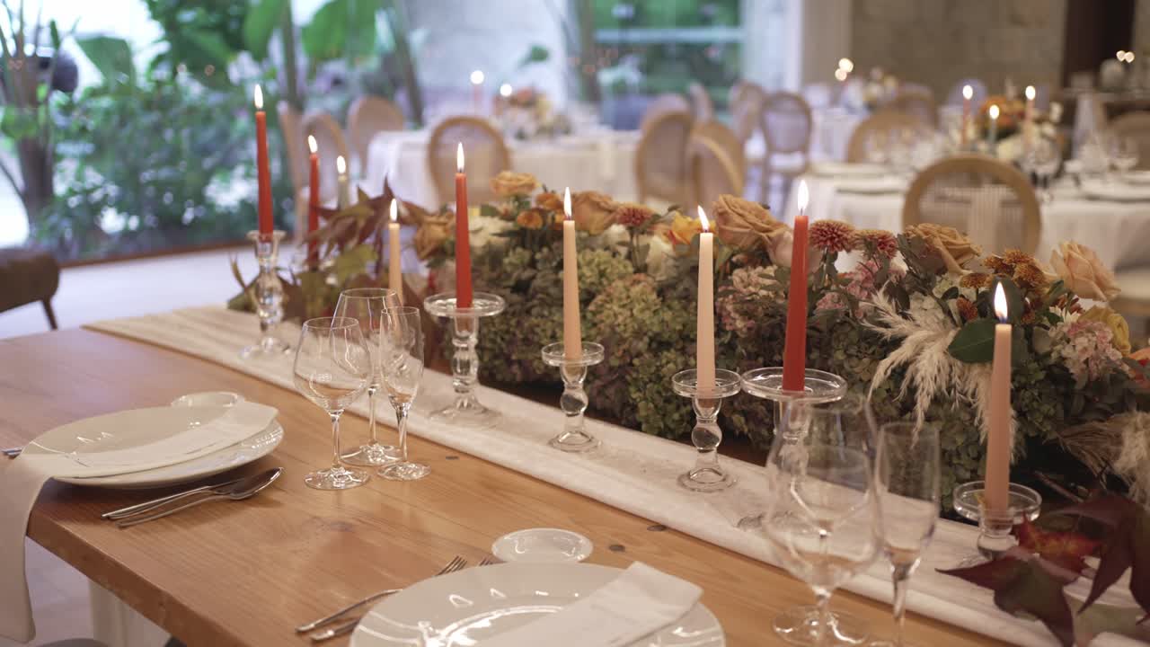 Long wedding table with terracotta candles, moss and dried floral runner in bright venue