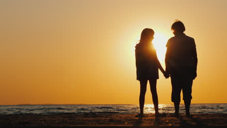 An-Elderly-Woman-Stands-Next-To-Her-Granddaughter-At-Sunset-Active-Seniors