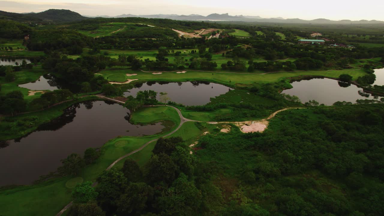 일몰 동안 태국의 언덕, 호수, 녹색이 있는 골프 코트 풍경의 아름다운 공중 전망