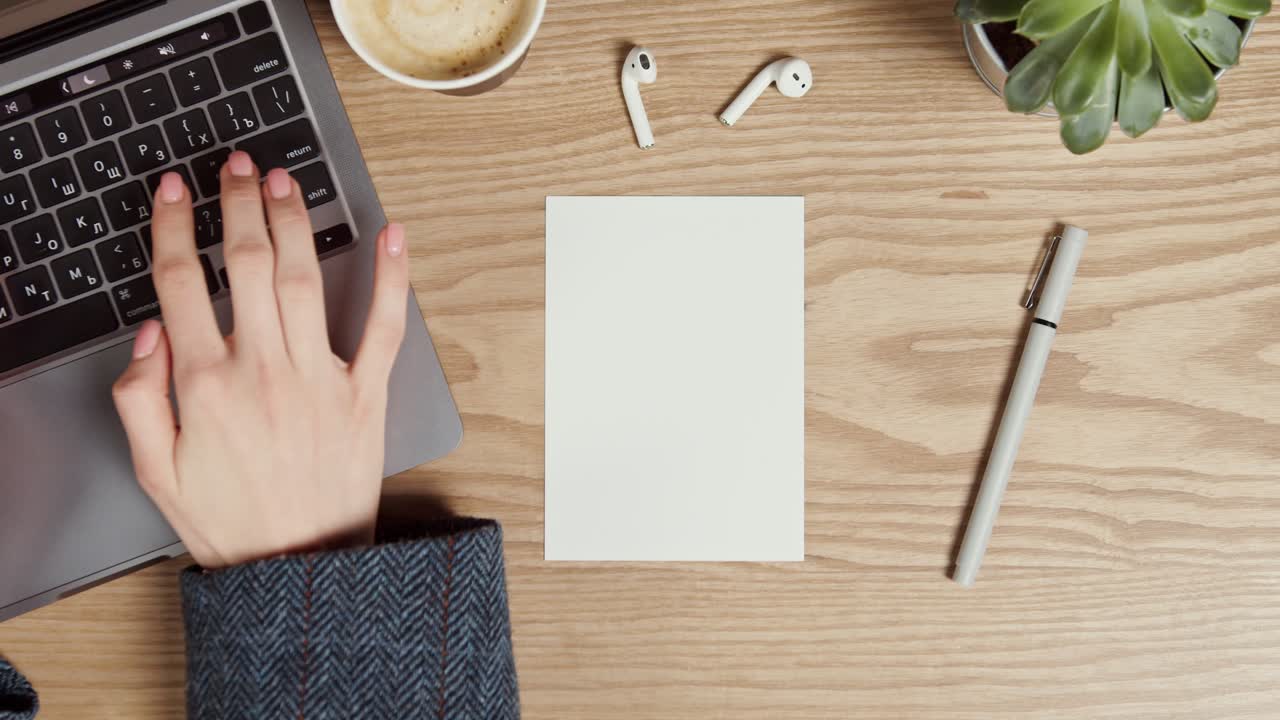 Woman working at a wooden desk with a laptop