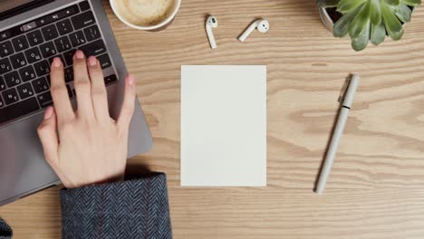 woman working at a wooden desk with a laptop