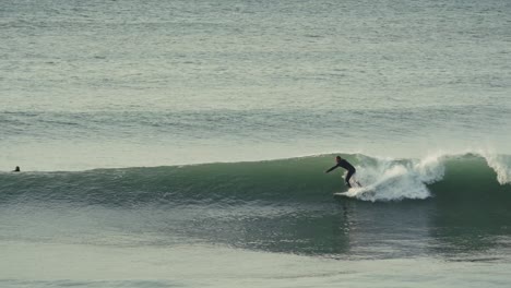 surfer catching wave, following view