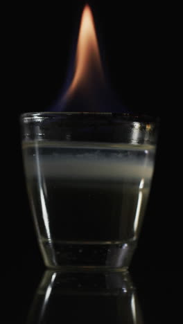 vertical video of lit alcohol flames and copy space on black background