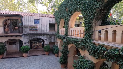 tilt-up from a cobblestoned courtyard to ivy covered arches, tlaquepaque, sedona, arizona