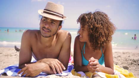 couple lying at each other on beach