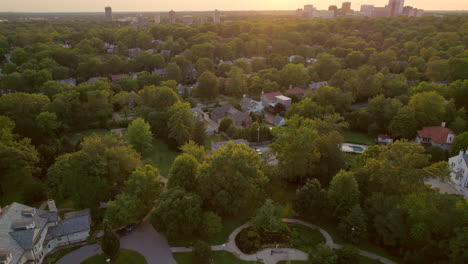 overhead beautiful clayton neighborhood with a tilt and descent to reveal downtown clayton city skyline on the horizon and sunset in st