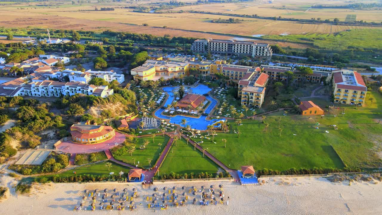 Looking down on beach chairs and hotels, with a hotel overlooking the beach.