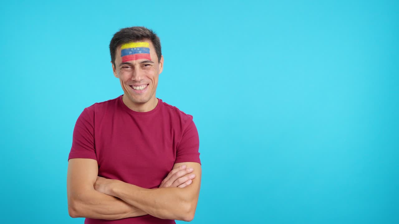 Homem de pé com bandeira venezuelana pintada no rosto sorrindo