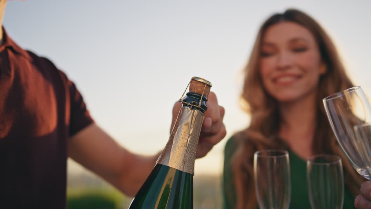 amigos sonrientes abren champán en la fiesta de fin de semana cerca. amigos celebrando