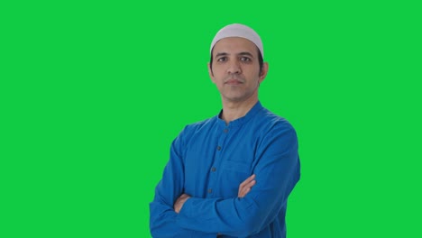 portrait of confident muslim man standing crossed hands green screen