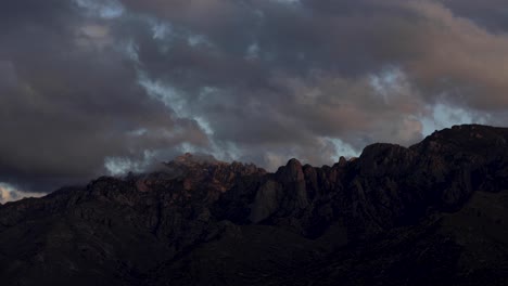 nubes malhumoradas y coloridas sobre las montañas catalina al atardecer, arizona, dolly out