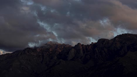 moody and colorful clouds over catalina mountains at sunset, arizona, dolly out