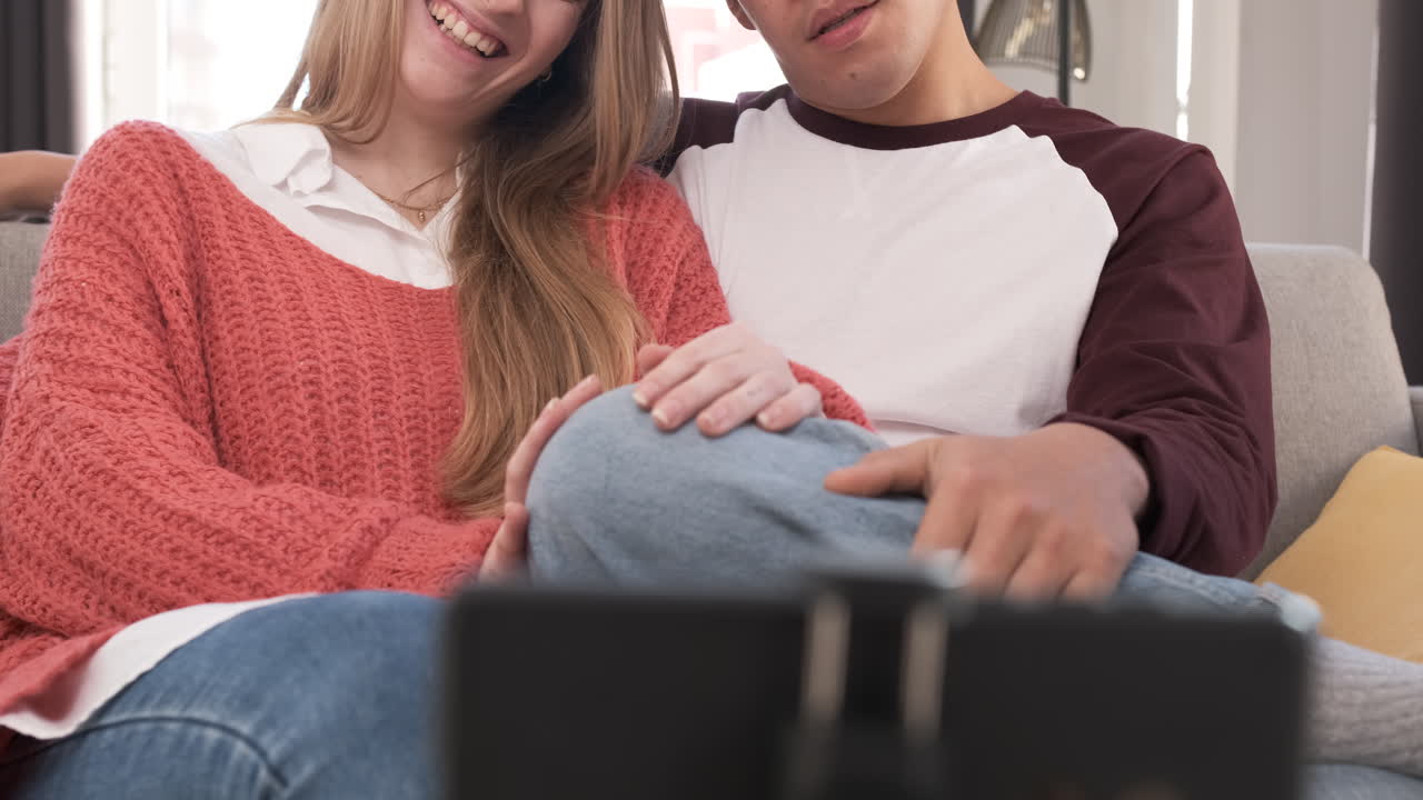 Portrait of a young unrecognized couple on a video call with their phone at home