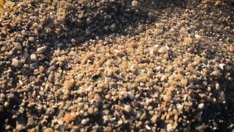 sunlight on the sand with pebbles and stones in mae haad beach, koh phangan, thailand - overhead shot