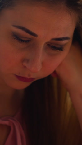 blonde young woman with absence of appetite picks food on plate suffering from unsuccessful romantic date at table in light room closeup slow motion