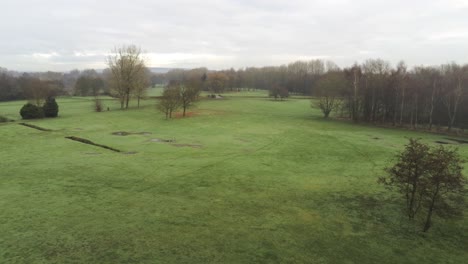 aerial view overcast frosty green golf course country club fairway pull back