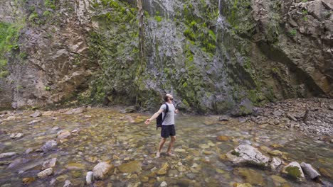 free man standing barefoot in the creek.