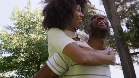 feliz pareja de raza mixta disfrutando en el jardín durante un día soleado