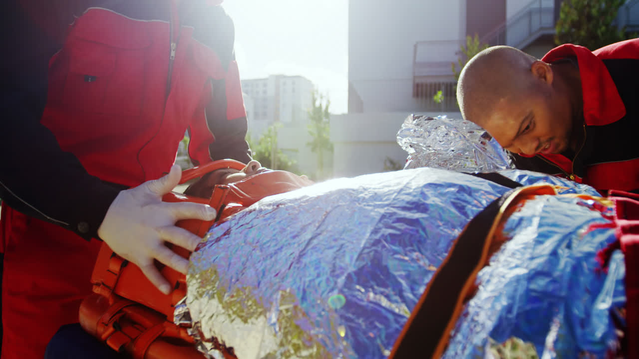 구급대원 들 이 배 에 누워 있는 소녀 에 벨트 를 고 있다