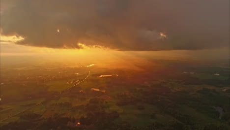 wunderschöne luftansicht des warmen sonnenlichts, das durch die wolken über die landschaft unten in lettland strahlt