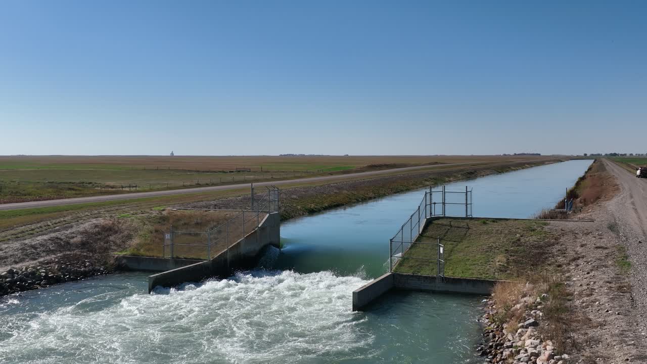 imágenes de 4k del tercio inferior del agua que fluye a través de un canal de riego en el sur de alberta