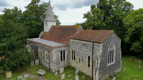 a push-in shot over a graveyard towards all saints church in west stourmouth