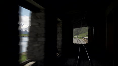 train passing through swiss landscape into tunnel