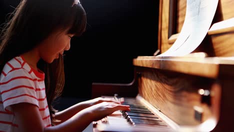 schoolgirl learning piano in music class 4k