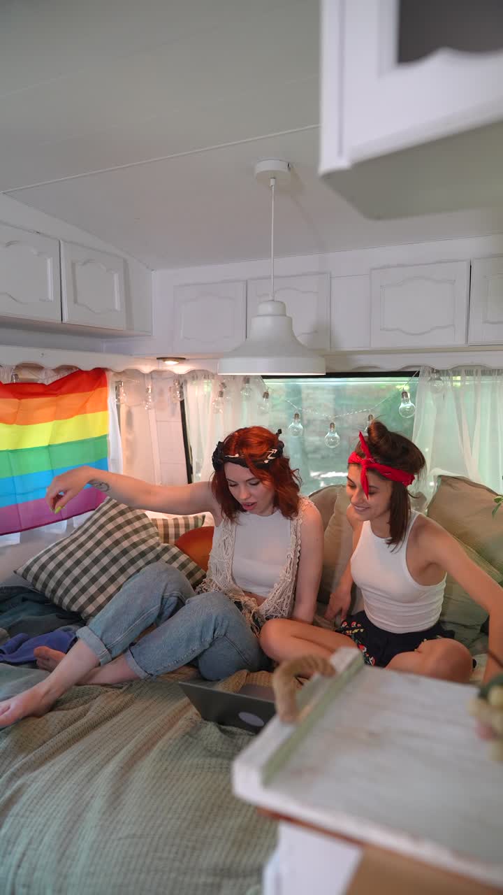 dos amigas usando una computadora portátil en una furgoneta