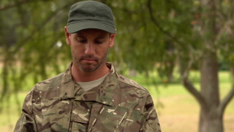 Soldier-looking-at-tablet-pc-in-park