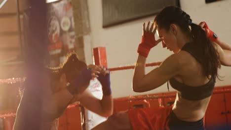 two female boxers practicing in boxing ring